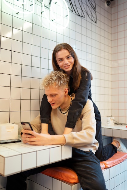 Pareja sonriente de tiro medio con teléfono