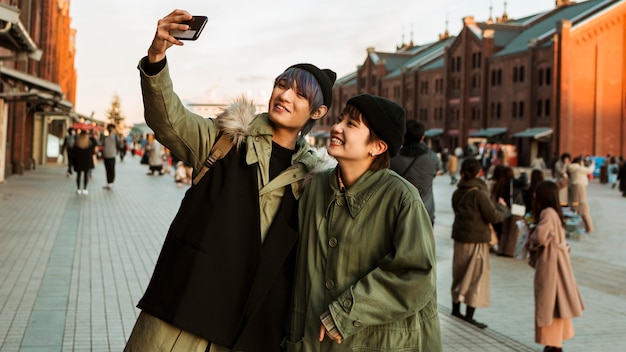 Pareja sonriente de tiro medio tomando selfie