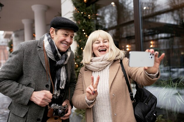 Pareja sonriente de tiro medio tomando selfie