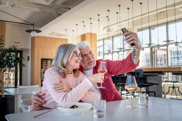 Pareja sonriente de tiro medio tomando selfie