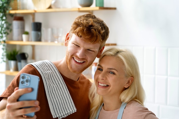 Foto gratuita pareja sonriente de tiro medio tomando selfie