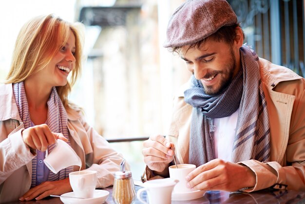 Pareja sonriente tomando un café