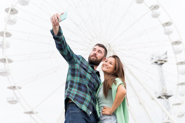 Pareja sonriente tomando selfie al aire libre