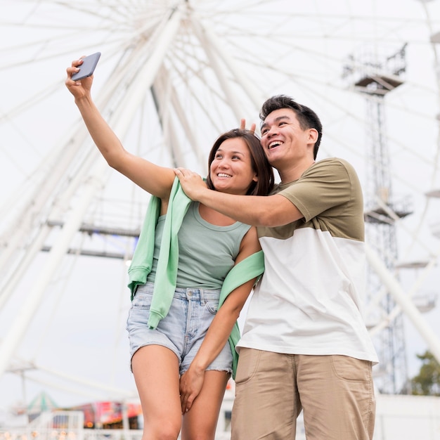 Pareja sonriente tomando selfie juntos