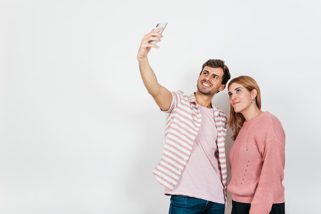 Pareja sonriente tomando selfie en el teléfono