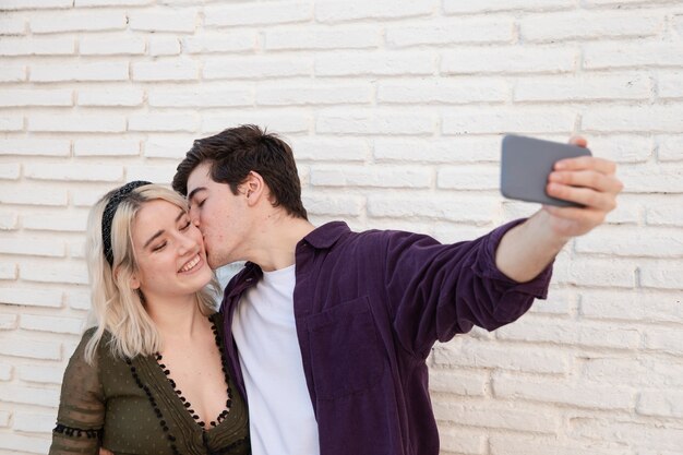 Pareja sonriente tomando una selfie