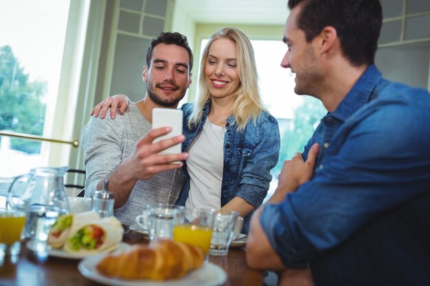 Pareja sonriente de tomar la foto desde el teléfono móvil