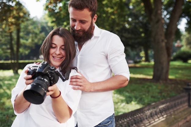 Pareja sonriente viendo imágenes en la cámara.