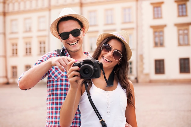 Pareja sonriente viendo imágenes en la cámara