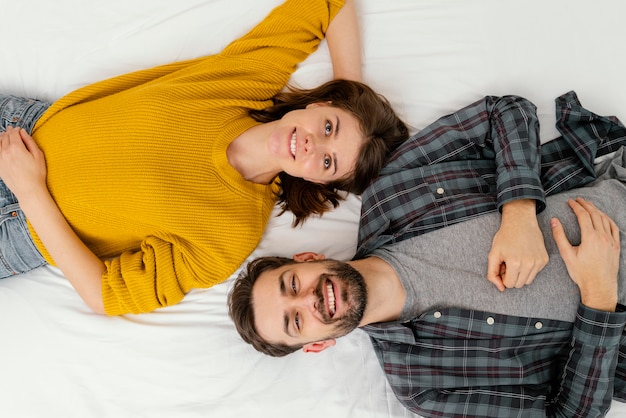 Pareja sonriente de vista superior en la cama