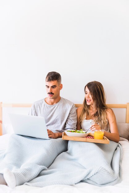 Pareja sorprendida comiendo ensalada y viendo la película