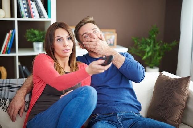 Pareja sorprendida viendo una película de terror