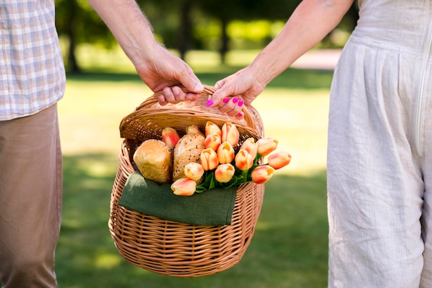 Pareja sosteniendo una cesta de picnic