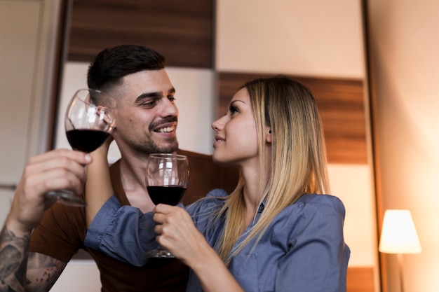 Pareja sosteniendo copas de vino mirándose