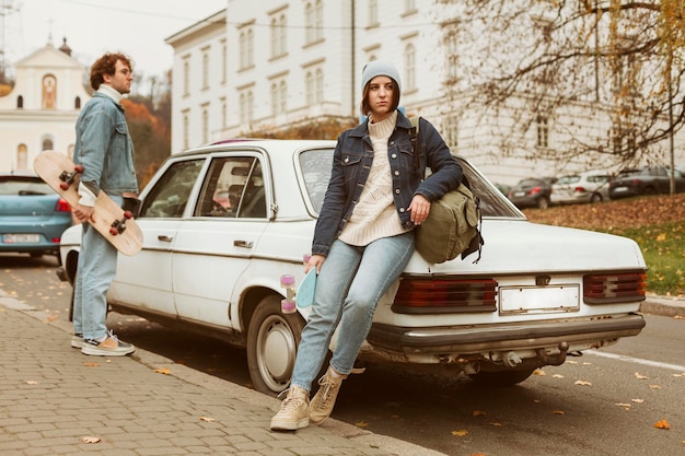 Foto gratuita pareja sosteniendo sus patinetas