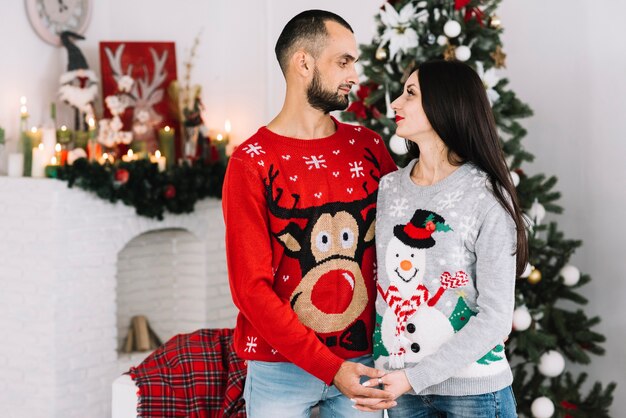 Pareja en suéteres de Navidad tomados de la mano