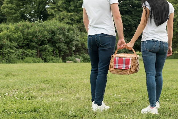 Pareja sujetando cesta de picnic