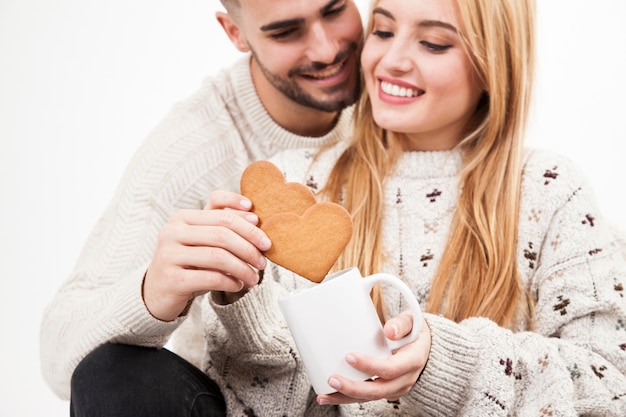 Pareja sumergiendo galletas en taza