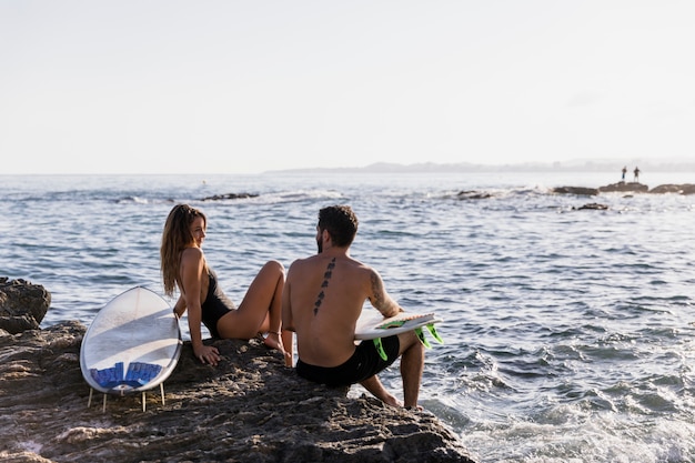 Pareja de surfers en la playa