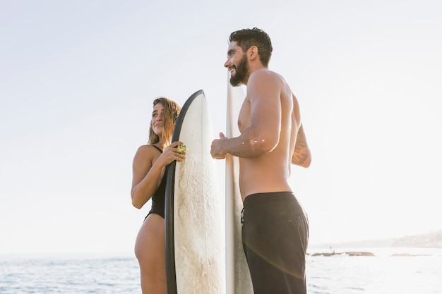 Foto gratuita pareja de surfers en la playa