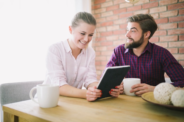 Pareja con tableta en la mesa