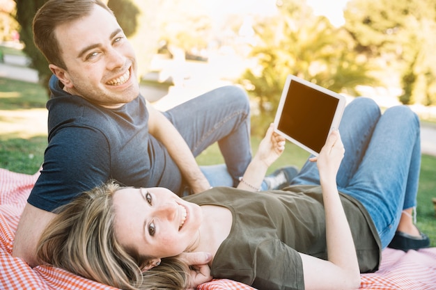 Foto gratuita pareja con tableta mirando la cámara