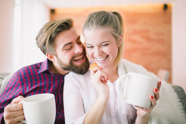 Pareja con tazas y galletas