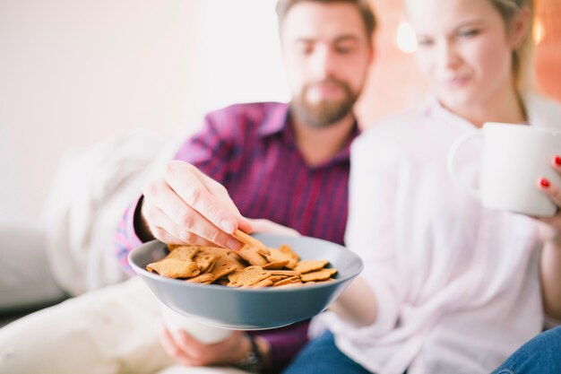 Pareja con tazas y galletas