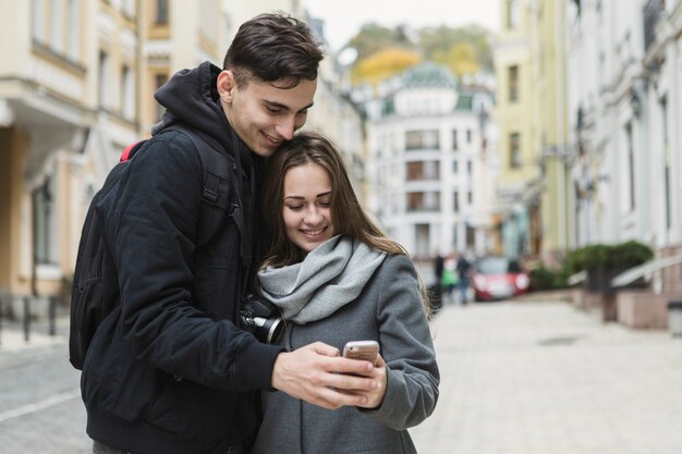 Pareja con teléfono inteligente en la calle