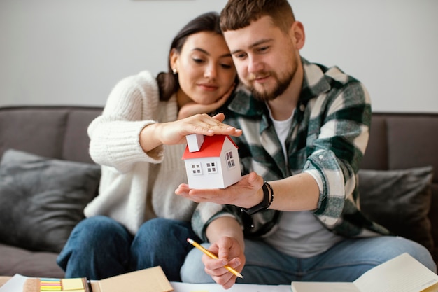 Pareja, tenencia, casa pequeña, plano medio