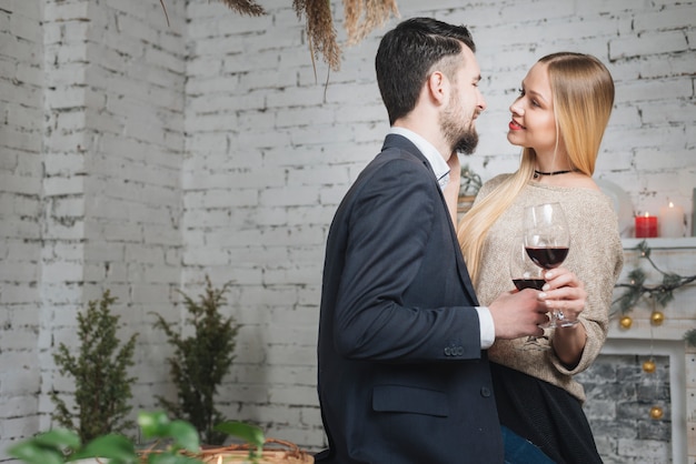 Foto gratuita pareja tierna con vino de pie cerca