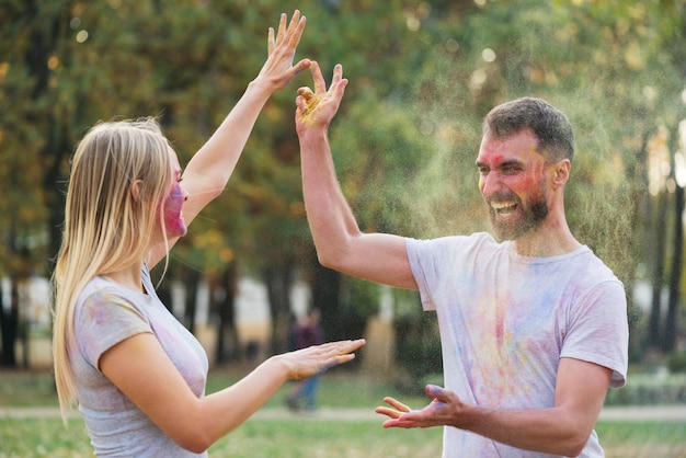 Pareja tirando pintura en polvo el uno al otro