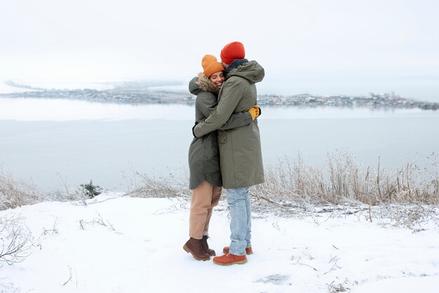 Pareja de tiro completo abrazándose al aire libre