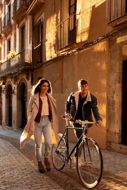 Foto gratuita pareja de tiro completo caminando con bicicleta