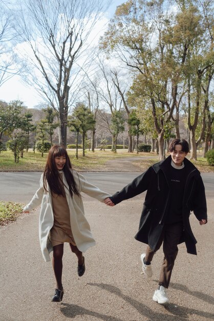 Pareja de tiro completo caminando juntos al aire libre