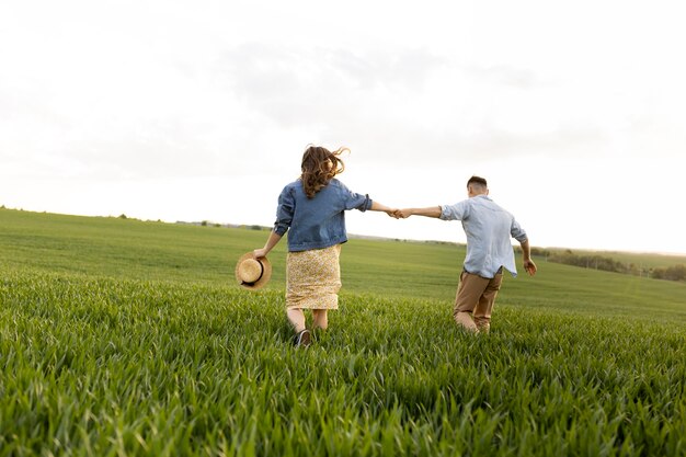 Pareja de tiro completo caminando juntos en la naturaleza