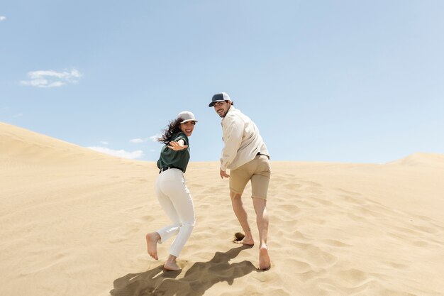 Pareja de tiro completo corriendo en el desierto