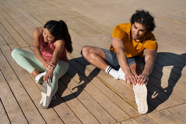 Foto gratuita pareja de tiro completo entrenando al aire libre