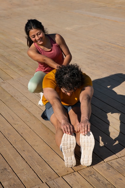 Foto gratuita pareja de tiro completo entrenando al aire libre