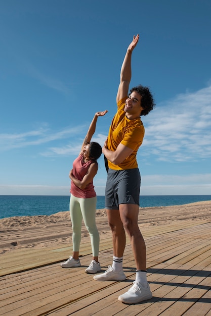 Foto gratuita pareja de tiro completo entrenando al aire libre