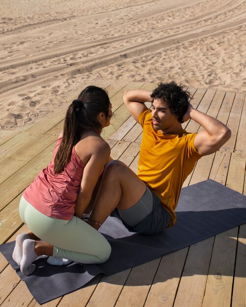 Foto gratuita pareja de tiro completo entrenando al aire libre