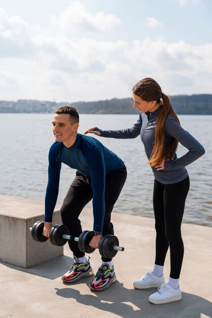 Pareja de tiro completo entrenando juntos al aire libre