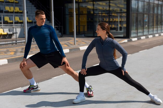 Pareja de tiro completo haciendo ejercicios de entrenamiento