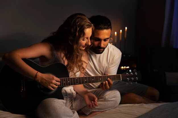 Pareja de tiro completo haciendo música con guitarra