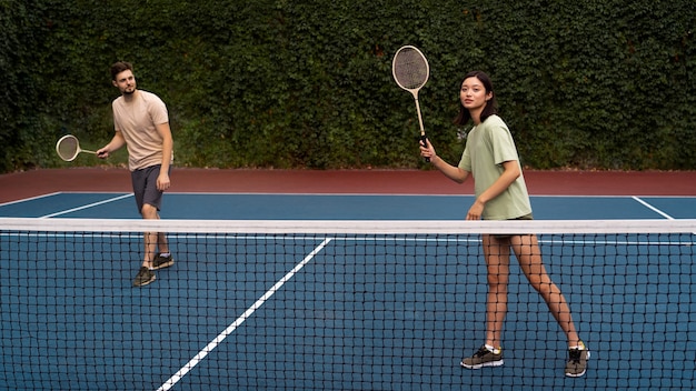 Pareja de tiro completo jugando bádminton