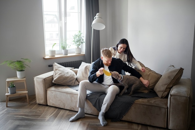 Pareja de tiro completo con lindo perro en casa