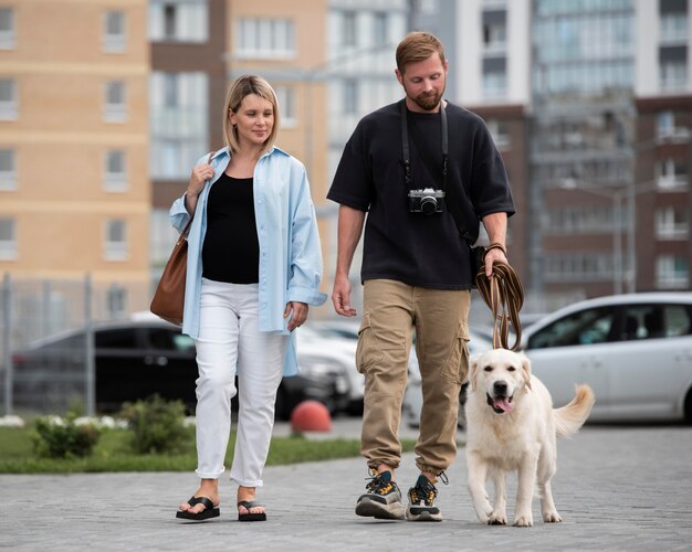 Pareja de tiro completo paseando a un perro