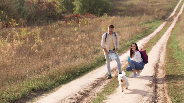 Pareja de tiro completo con perro en el campo