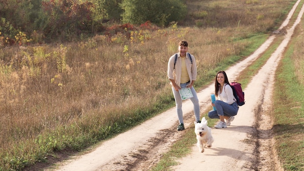 Pareja de tiro completo con perro en el campo