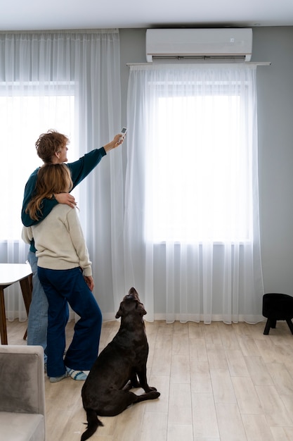 Pareja de tiro completo y perro en casa.